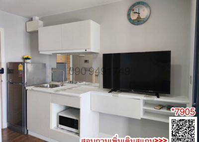 Modern kitchen with integrated appliances and television