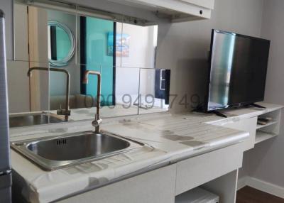 Compact modern kitchen with stainless steel sink, white cabinetry, and modern appliances