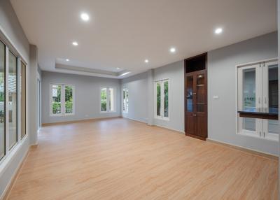 Spacious and well-lit empty living room with hardwood floors