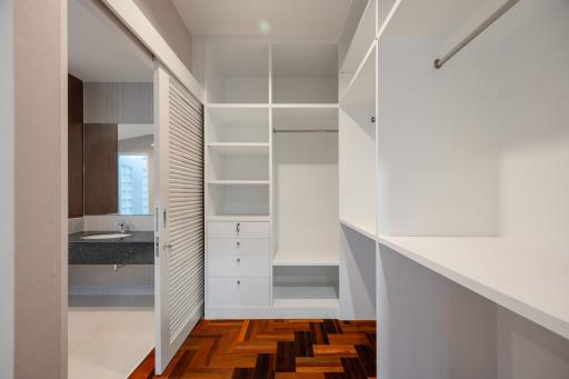 Modern walk-in closet with built-in shelves and herringbone pattern flooring