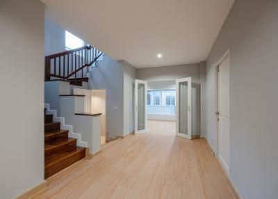 Spacious and well-lit entryway with staircase and hardwood flooring