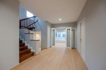 Spacious and well-lit entryway with staircase and hardwood flooring
