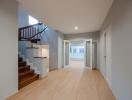 Spacious and well-lit entryway with staircase and hardwood flooring