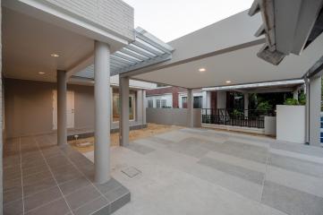 Spacious tiled patio with pillars and covered area