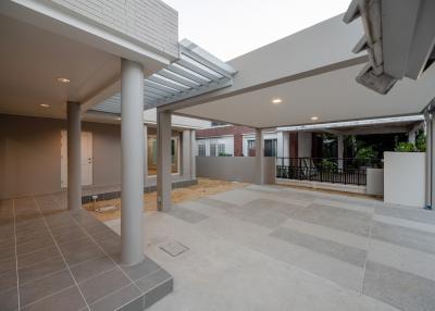 Spacious tiled patio with pillars and covered area