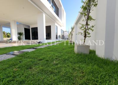 Modern building exterior with green lawn and spacious design