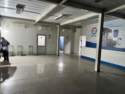 Spacious commercial area with tiled flooring and ceiling-mounted lighting