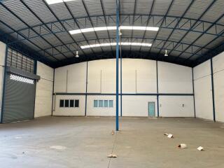 Spacious industrial warehouse interior with high ceiling and empty floor