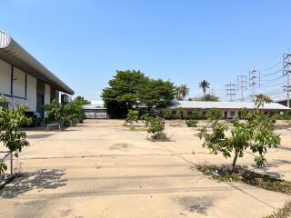 Spacious outdoor area with industrial buildings and greenery