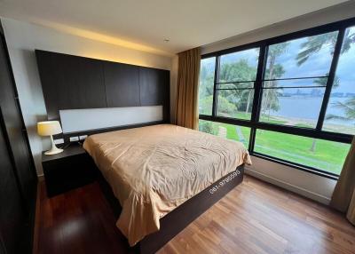 Modern bedroom with large windows overlooking a lake