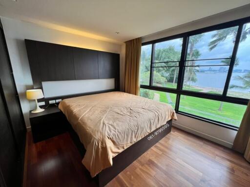 Modern bedroom with large windows overlooking a lake