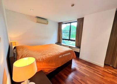 Cozy bedroom with a large bed, hardwood floors, and natural light