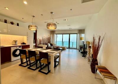 Modern open-concept living space with kitchen, dining area, and view of the balcony
