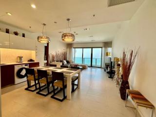 Modern open-concept living space with kitchen, dining area, and view of the balcony