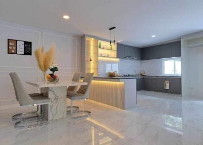 Modern kitchen with dining area, sleek design, and bright lighting