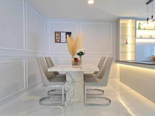 Modern dining area with elegant table and chairs set against a white interior