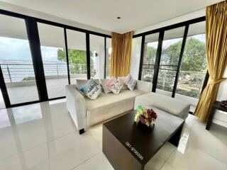 Spacious living room with modern furniture and large windows offering a view of the outdoors