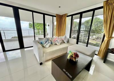 Spacious living room with modern furniture and large windows offering a view of the outdoors