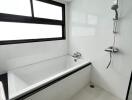 Modern bathroom interior with white tiling and bathtub