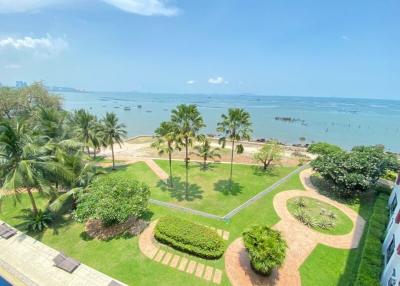 View from balcony overlooking the sea, palm trees, and landscaped garden