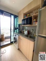 Compact modern kitchen with stainless steel appliances and balcony access