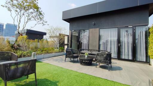 Modern outdoor patio with furniture and artificial grass