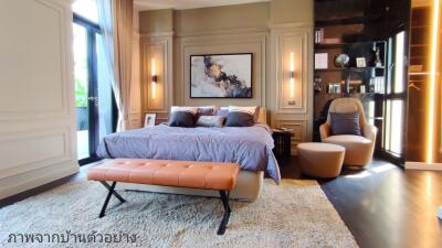 Elegant bedroom with large bed, seating, and artwork