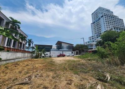 Vacant lot with potential for development near residential buildings under a clear blue sky