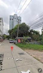 Street view of a residential area with high-rise building in the background