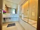 Modern bathroom interior with bathtub and glass shower partition