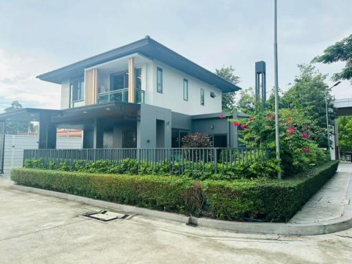 Modern two-story house with a well-maintained garden and clear skies