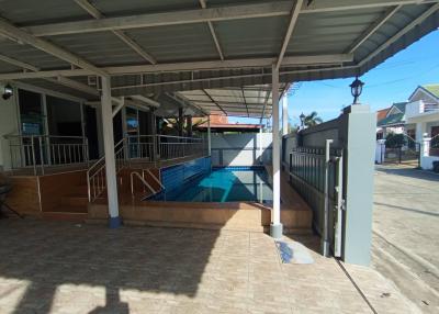 Spacious outdoor area with swimming pool and covered patio