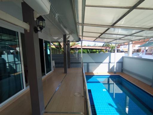 Spacious covered patio area adjacent to a private swimming pool