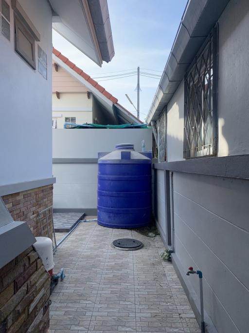 Compact side yard with a water storage tank and utility area