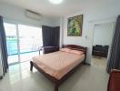 Spacious bedroom with a double bed, air conditioning unit and pool view.