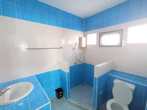 Bright bathroom with blue tile, shower, and white fixtures