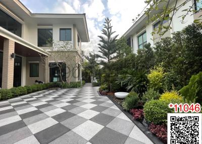 Elegant house exterior with checkered pathway and landscaped garden