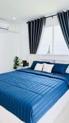 Bright and modern bedroom with blue bedding and large window