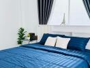 Bright and modern bedroom with blue bedding and large window