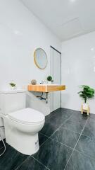 Modern bathroom with white walls and dark tiled floor