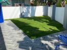 Spacious Backyard with Green Lawn and Tiled Patio Area