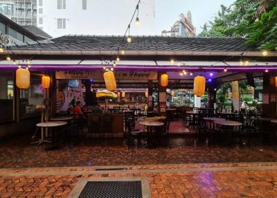 Outdoor dining area with string lights and wet floor after rain