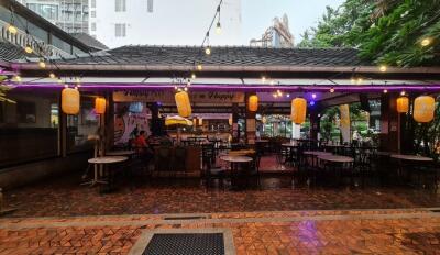 Outdoor dining area with string lights and wet floor after rain