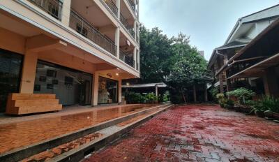 Exterior view of a residential building with red-tiled courtyard