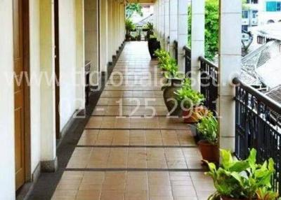 Brightly lit corridor with decorative plants in an apartment complex