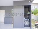 Modern home laundry room with washer and storage cabinets