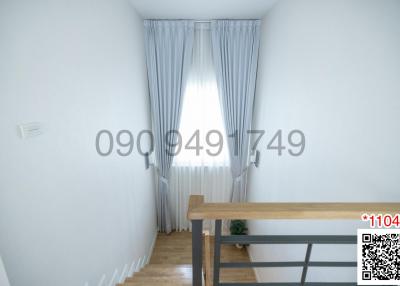 Bright hallway in residential building with wooden banister and stairway