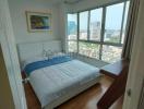 Bright bedroom with large window and city view