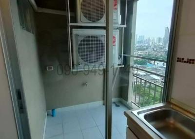 Compact utility area with city view, air conditioning units, and laundry facilities