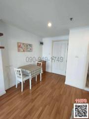 Compact dining room with wooden flooring and white walls